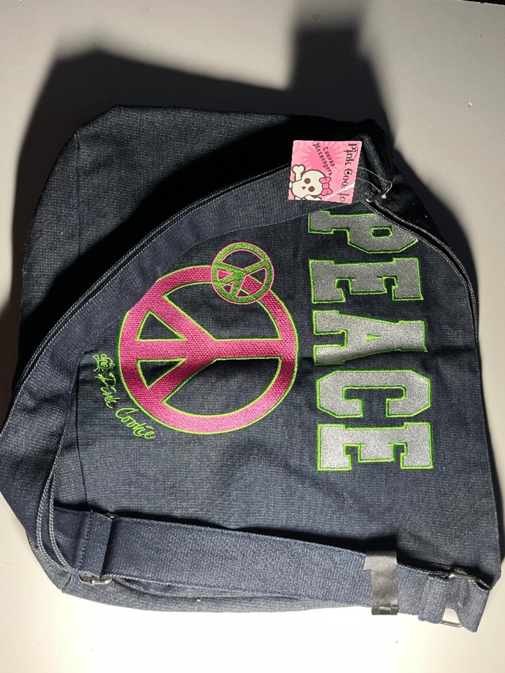 Pink Cookie messenger bag, embroidered with word "PEACE" on the front
